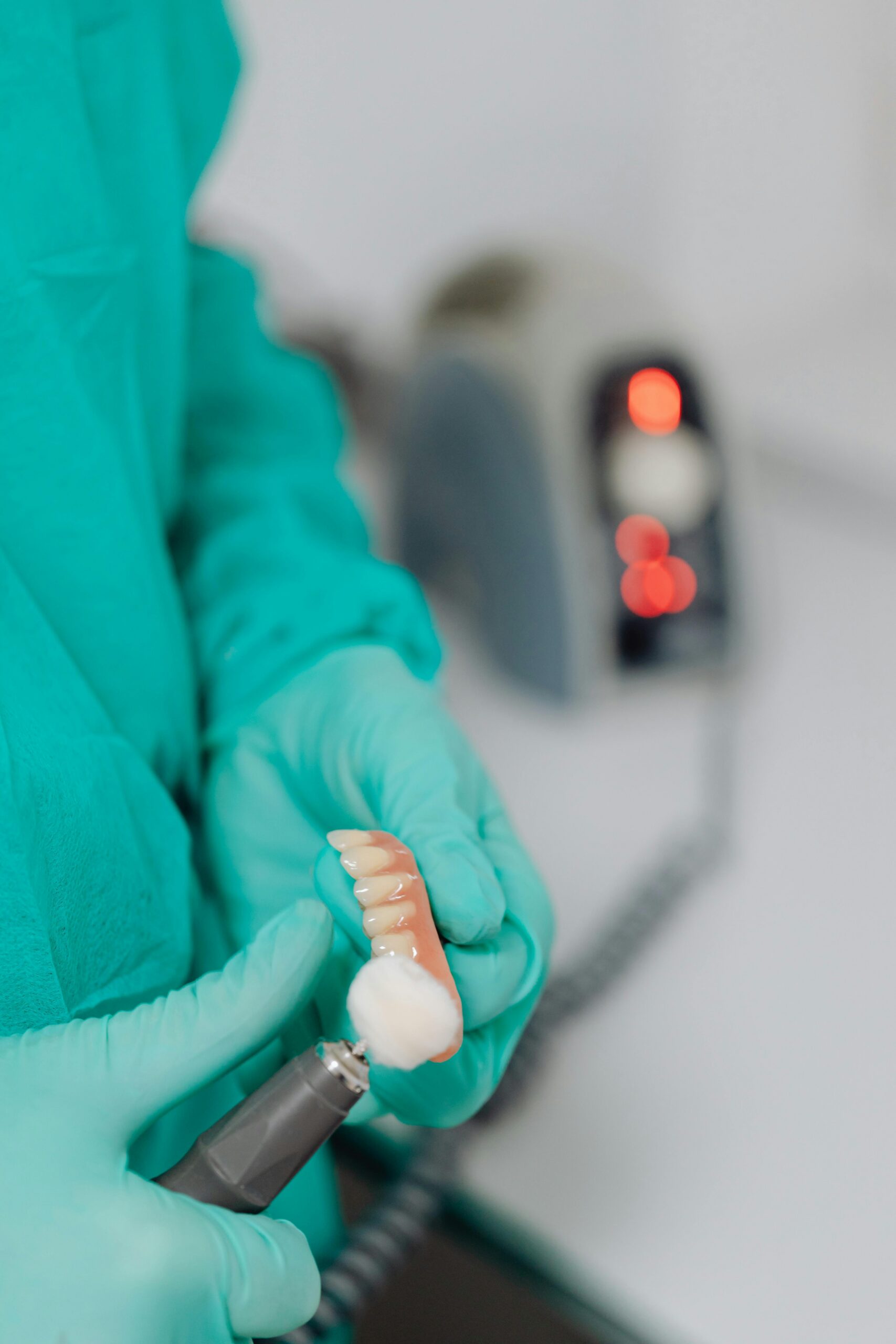 Dentist polishing dentures with precision in a dental clinic setting.